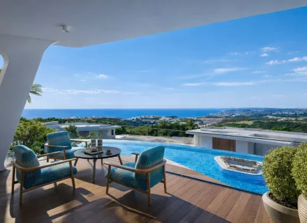 Luxury private terrace with infinity pool, lounge seating and panoramic views of the sea and coastline.