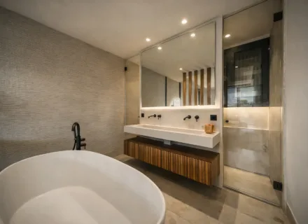 Modern bathroom with freestanding bathtub, double sink vanity, wooden cabinet, large mirror and walk-in