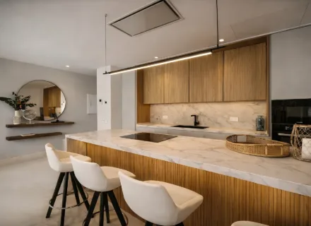 Modern kitchen with marble island, wooden cabinets, built-in appliances, minimalist lighting and bar stools.