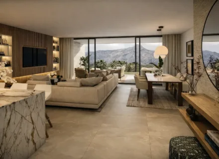 Spacious open-plan living and dining area with modern sofa, marble kitchen island, large windows and panoramic mountain views.