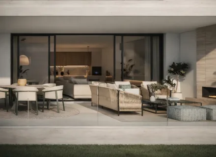 Modern covered terrace with outdoor sofa, dining table, glass railing, fireplace and seamless connection to the living room.