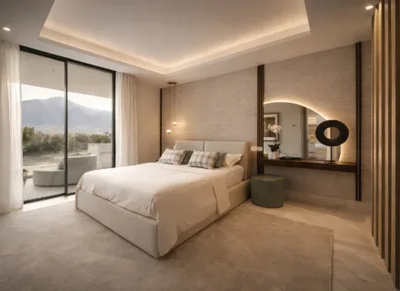 Modern bedroom with double bed, soft lighting, textured walls, vanity area and sliding doors opening to a terrace with views.
