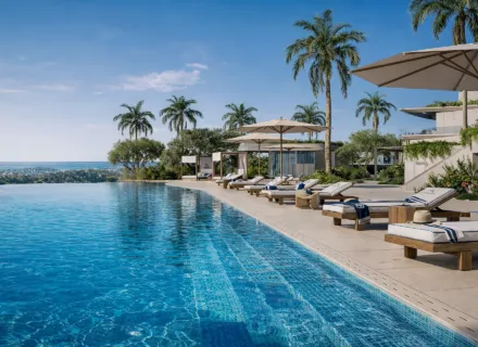 Azurean Marbella infinity pool with sun loungers, palm trees, sea views and exclusive luxury residential lifestyle