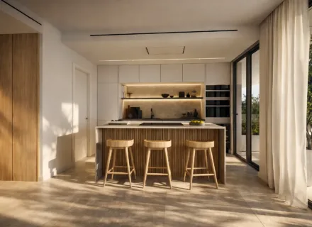 Minimalist open-plan kitchen with wooden island, bar stools, built-in appliances and soft natural light in luxury apartment.