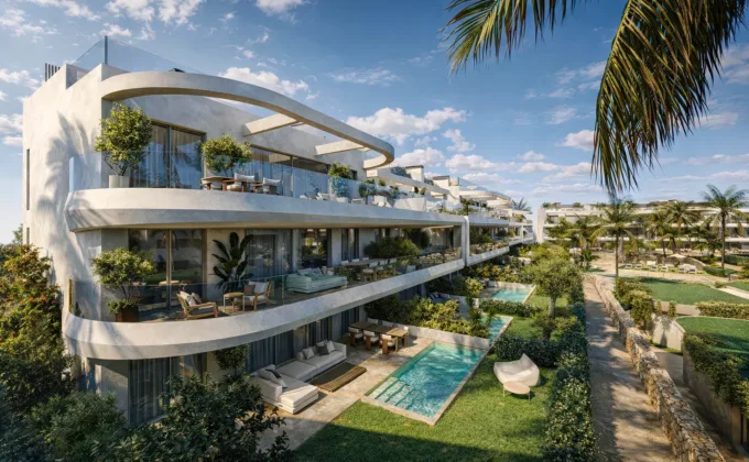 Modern luxury apartments with curved glass terraces, private pools, lush gardens and palm trees in sunny Estepona, Spain.