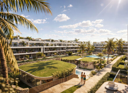 Elegant apartment complex with lush gardens, palm trees, swimming pool and sunny courtyard in Estepona, Spain.