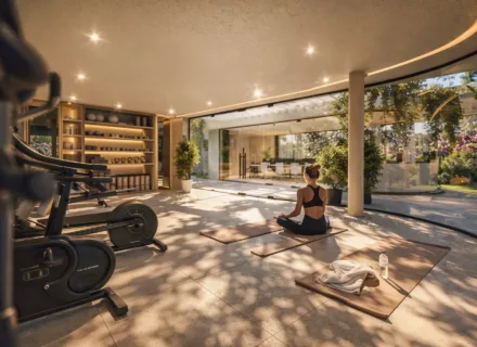 Modern gym and yoga space with exercise equipment, natural light and garden views in luxury residence.