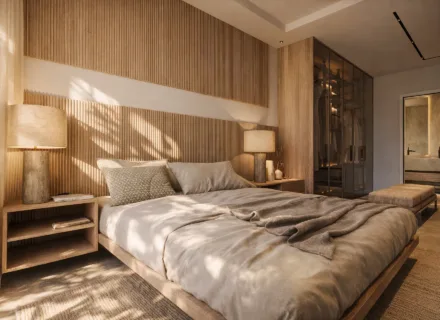 Elegant master bedroom with wooden panel wall, soft lighting, built-in wardrobe and warm natural tones in luxury apartment.