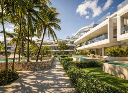 Luxury apartment complex surrounded by palm trees, landscaped gardens and private pools under bright Mediterranean sky.