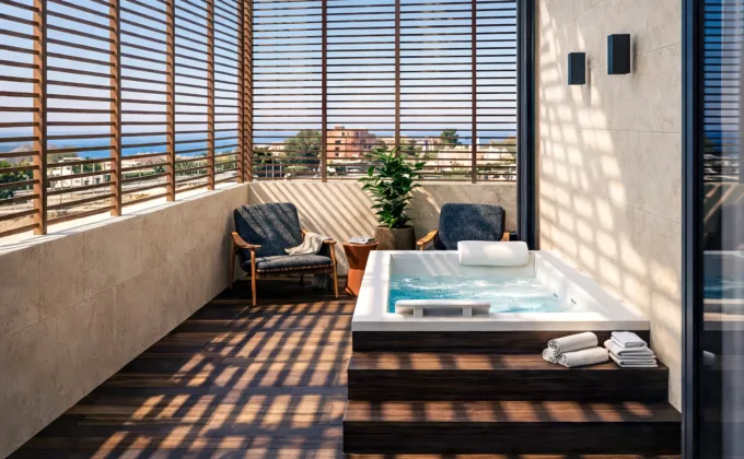 Prywatny taras z jacuzzi, drewnianymi przesłonami i widokiem na morze.