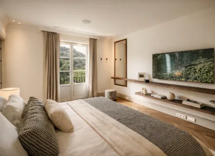 Serene bedroom at Villa Liora in Marbella with terrace access, elegant furnishings, soft tones and peaceful green views