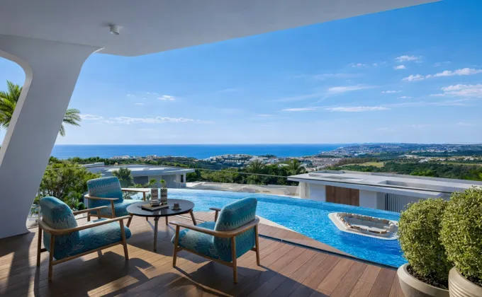 Luxury private terrace with infinity pool, lounge seating and panoramic views of the sea and coastline.