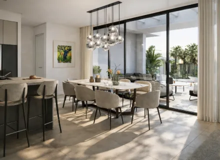 Bright open-plan dining area at Ayana Estepona with modern kitchen island, elegant seating and direct access to a sunny terrace.