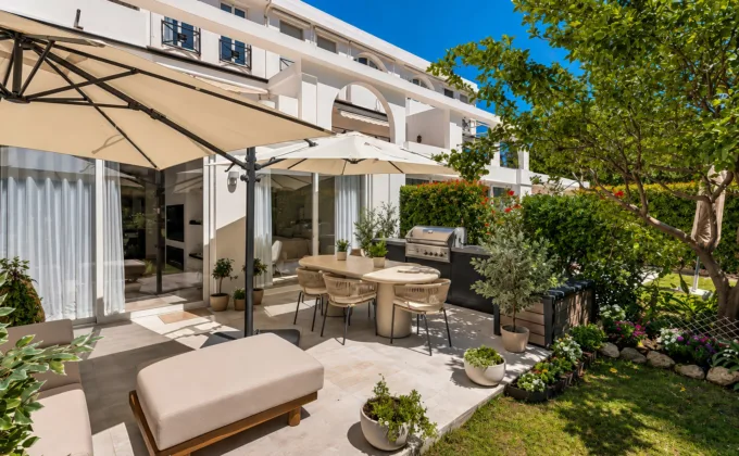 Apartament na sprzedaż Benahavís – słoneczny taras z prywatnym ogrodem, jadalnią na świeżym powietrzu, grillem i eleganckimi meblami wypoczynkowymi.